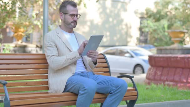 Modern Casual Man Using Tablet While Sitting Outdoor Bench — Stock Video