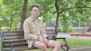Diş ağrısı olan modern genç adam Bench 'te oturuyor.