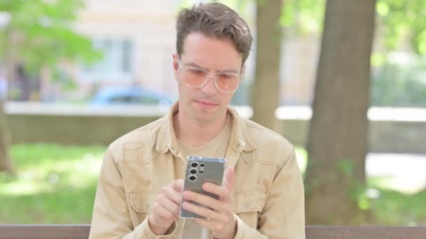 Casual Young Man Περιήγηση Στο Internet Στο Smartphone Outdoor — Αρχείο Βίντεο