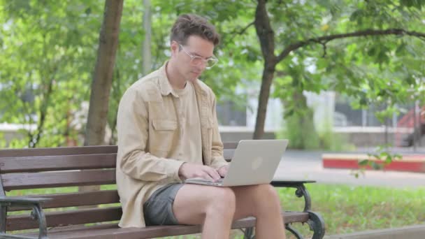 生病的现代年轻人咳嗽和使用笔记本电脑室外 — 图库视频影像