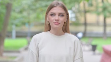 Kendine güvenen bir kadının açık hava portresi insanları davet ediyor.