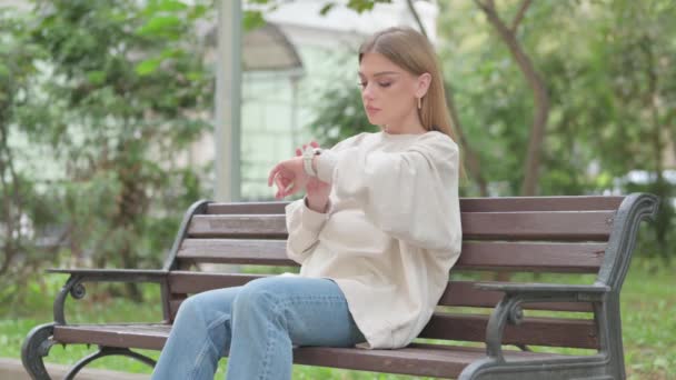 Casual Νεαρή Γυναίκα Χρησιμοποιώντας Smart Watch Εξωτερική — Αρχείο Βίντεο