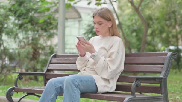 Nenucená Mladá Žena Šokována Ztrátou Telefonu Zatímco Sedí Venku Lavičce — Stock video