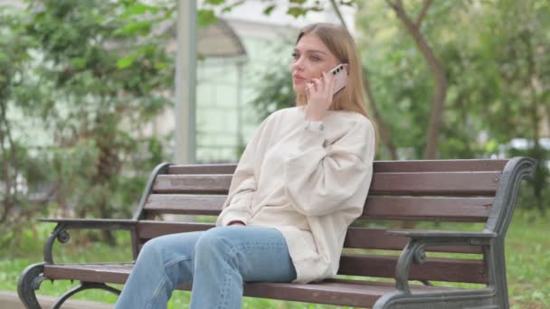 Casual Νεαρή Γυναίκα Μιλάει Στο Τηλέφωνο Ενώ Κάθεται Ένα Μπαλκόνι — Αρχείο Βίντεο
