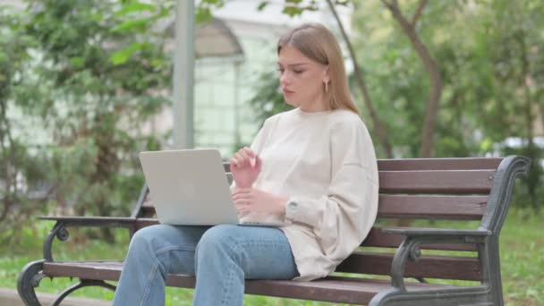 Wrisk Pain アウトドアでラップトップを使用しているカジュアルな若い女性 — ストック動画