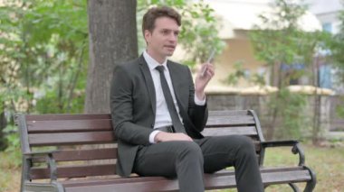 Kızgın genç iş adamı telefonda konuşuyor.
