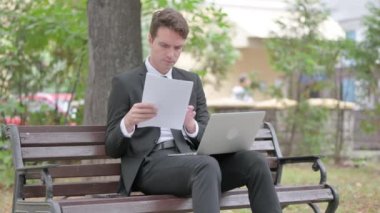Genç İşadamı Dokümanlar ve Laptop üzerinde çalışıyor