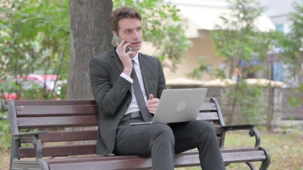 Młody Biznesmen Rozmawia Przez Telefon Korzystania Laptopa Odkryty — Wideo stockowe