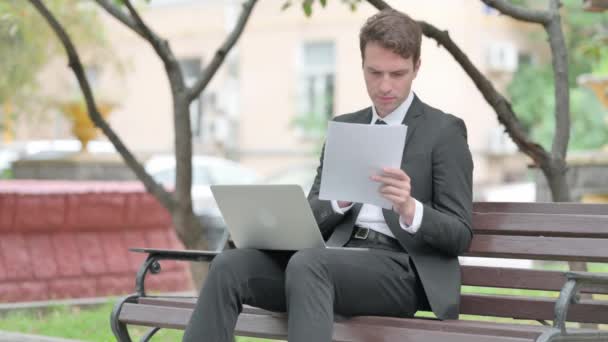 Бизнесмен Расстроен Чтении Контракта Использовании Ноутбука Открытом Воздухе — стоковое видео