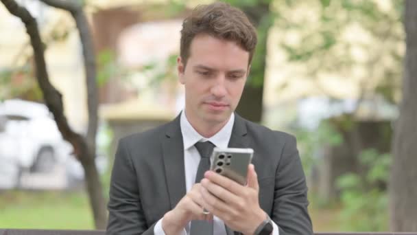 Zdenerwowany Młody Biznesmen Wstrząśnięty Smartfon Odkryty — Wideo stockowe