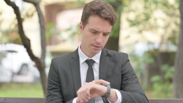 Młody Biznesmen Korzystający Inteligentnego Zegarka Outdoor — Wideo stockowe