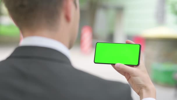 Affärsman Horisontellt Hålla Smartphone Med Grön Skärm Utomhus — Stockvideo