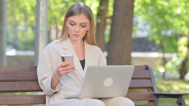 Laptop ve Smartphone 'da çalışan genç iş kadını