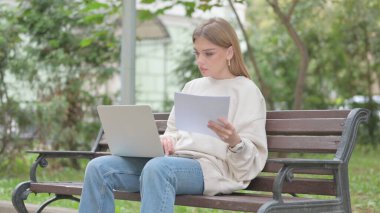 Evraklar ve Laptop üzerinde çalışan sıradan bir genç kadın.