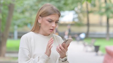 Genç Kadın dışarıda akıllı telefondan şok oldu.