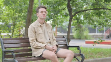 Benç 'te oturan modern genç adam.