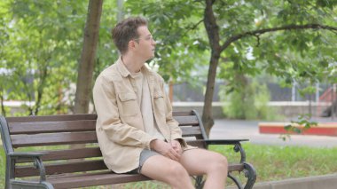 Modern Genç Adam Park 'taki Bench' e gelip oturuyor.