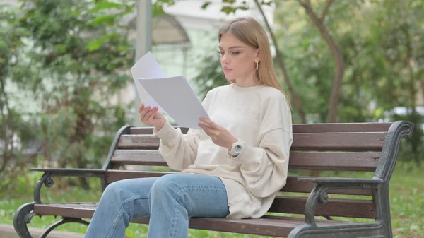 stock image Casual Young Woman Reading Documents while Sitting Outdoor