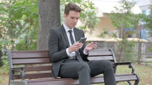 Junger Geschäftsmann Kauft Online Ein Während Draußen Sitzt — Stockfoto