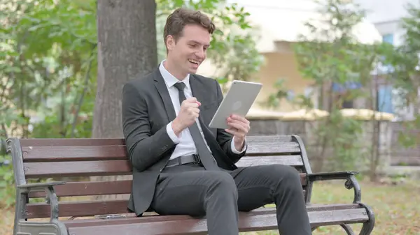 Jovem Empresário Comemorando Tablet Enquanto Sentado Livre Banco — Fotografia de Stock
