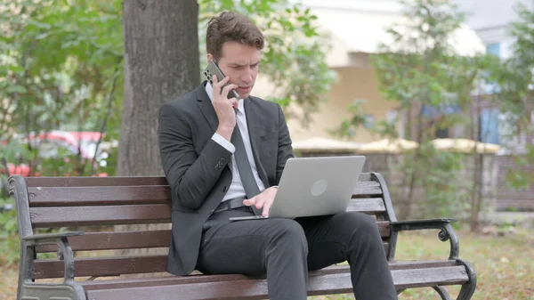 Junger Geschäftsmann Telefoniert Und Nutzt Laptop Freien — Stockfoto