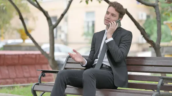 Empresario Hablando Por Teléfono Mientras Está Sentado Banco — Foto de Stock