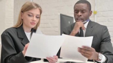 İş kadını ve Afrikalı İşadamı Ofiste İş Raporunu Tartışıyor