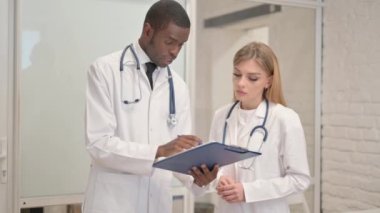 Kıdemli Afrikalı Doktor kadın doktorla tıbbi rapor hakkında konuşuyor.