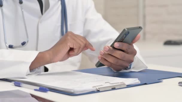Close Doutor Africano Usando Smartphone Hospital — Vídeo de Stock