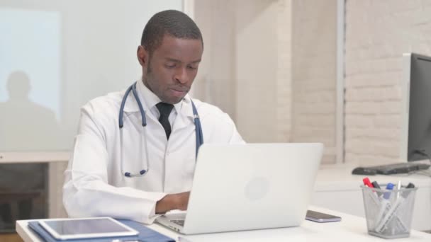 Médico Africano Sorrindo Para Câmera Enquanto Trabalhava Laptop Hospital — Vídeo de Stock