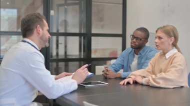 Erkek Doktor Karışık Irk Çifti ile Konuşuyor