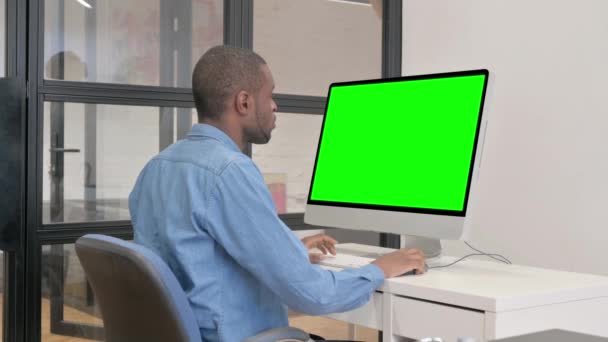 緑のスクリーンが付いているコンピュータを使用するアフリカの男 — ストック動画