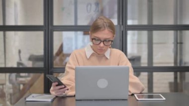 Laptop 'ta Çalışan ve Akıllı Telefon Kullanan Genç Kadın