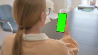 Yeşil ekranlı telefon kullanan kadın