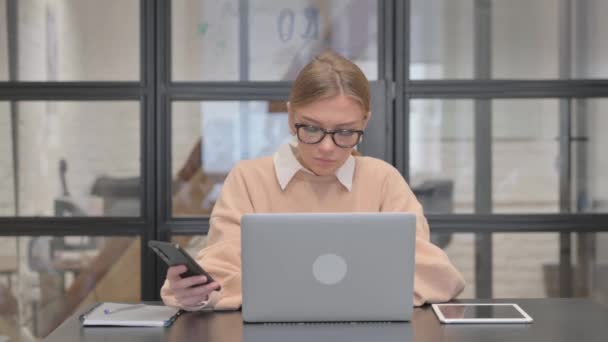 Mladá Žena Pracující Notebooku Pomocí Chytrého Telefonu — Stock video