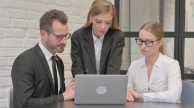 Dizüstü bilgisayarda çalışan ciddi iş adamları