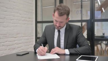 Belgeler üzerinde çalışan Orta Çağ İşadamı