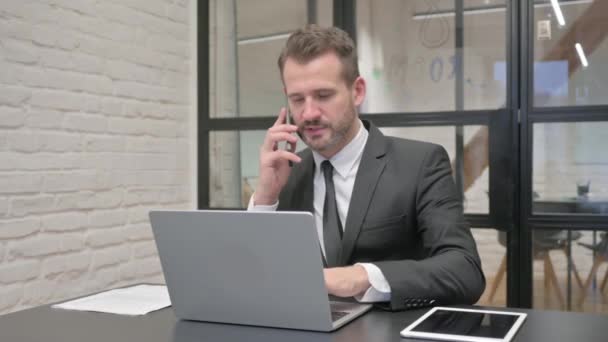 Középkorú Üzletember Beszél Telefonon Munkahelyen — Stock videók