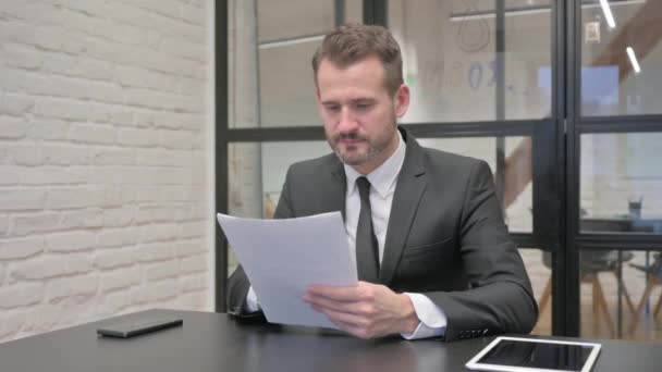 中高年ビジネスマン職場で文書を読む — ストック動画