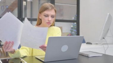 Genç Sarışın Kadın Belgeler ve Dizüstü bilgisayarla Çalışırken Şok Oldu