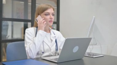 Kadın Doktor İş yerinde Telefonla Konuşuyor