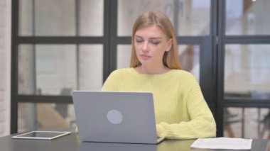 Dizüstü bilgisayarda çalışırken kamerayı gösteren sıradan yaratıcı kadın.