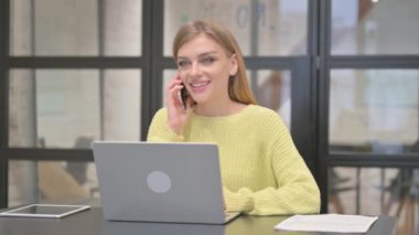 İş yerinde yaratıcı bir kadın telefonda konuşuyor.
