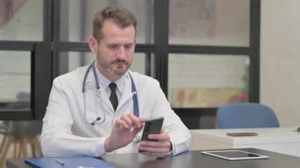 Μεσήλικας Γιατρός Χρησιμοποιώντας Smartphone Για Online Περιήγηση — Αρχείο Βίντεο