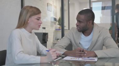 Genç bayan lider Afrikalı takım arkadaşıyla konuşuyor.