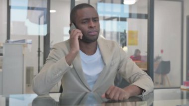Afrikalı adam telefonda konuşuyor, pazarlık yapıyor.