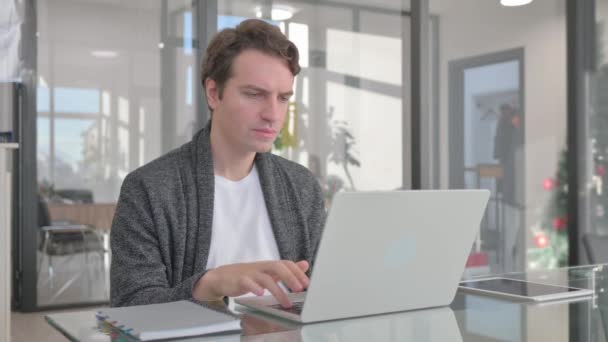 Młody Człowiek Zszokowany Stratą Laptopie Biurze — Wideo stockowe
