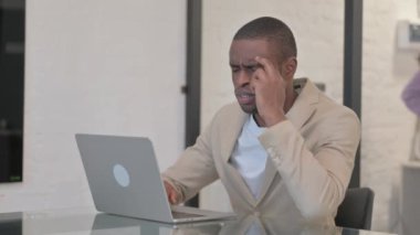 Afro-Amerikan Adam 'ın baş ağrısı var, dizüstü bilgisayarda yazıyor.