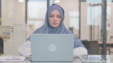 Bilgisayarda çalışırken kameraya bakan şok olmuş Arap Kadın
