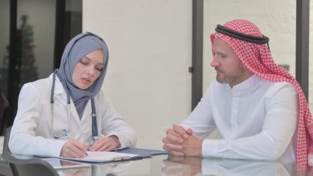 Γυναίκα Γιατρός Συζητώντας Ιατρική Έκθεση Για Τον Άραβα Ασθενή — Αρχείο Βίντεο